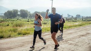A group of runners enjoys a vibrant morning jog on a rural dirt road.